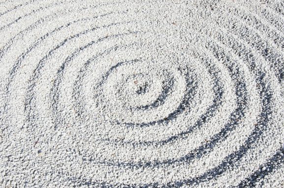 A pattern of concentric circles created by white sand or fine material.